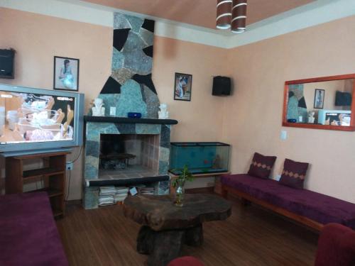 a living room with a couch and a fireplace at Cabaña El Salto in Cuetzalán del Progreso