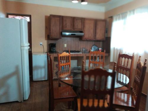 a kitchen with a table and chairs and a refrigerator at Cabaña El Salto in Cuetzalán del Progreso