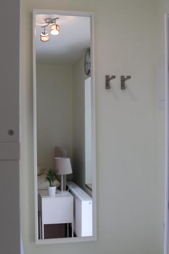 a mirror reflecting a room with a table and a lamp at SLO. Apartments in Bakov nad Jizerou