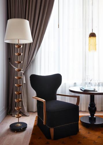 a room with a chair and a table and a lamp at Maison Metier, in the Unbound Collection by Hyatt in New Orleans
