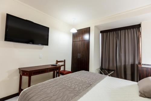 a hotel room with a bed and a flat screen tv at Aguas do Iguaçu Hotel Centro in Foz do Iguaçu