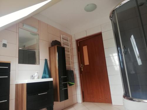a bathroom with a sink and a wooden door at Boczna 9 Apartament in Karpacz