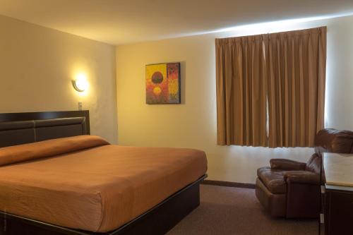 une chambre d'hôtel avec un lit et une chaise dans l'établissement BONITTO INN® Tampico Aeropuerto, à Tampico
