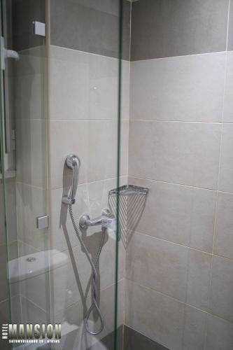 a shower in a bathroom with a glass door at Mansion Hotel in Athens