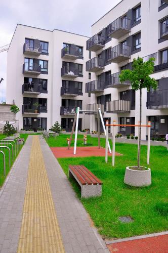 a park with a bench in front of a building at Apartments Franny's Bees in Vilnius