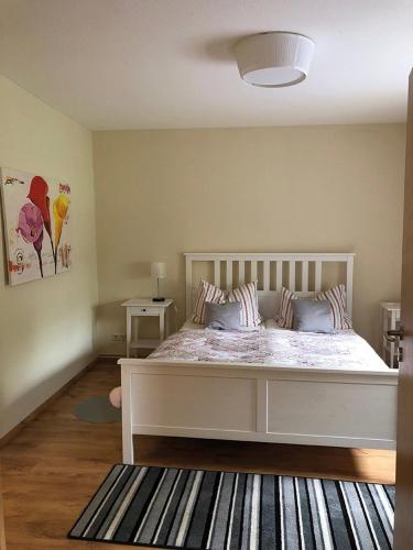 a bedroom with a white bed and a rug at Ferienwohnung am Storchennest in Schnackenburg