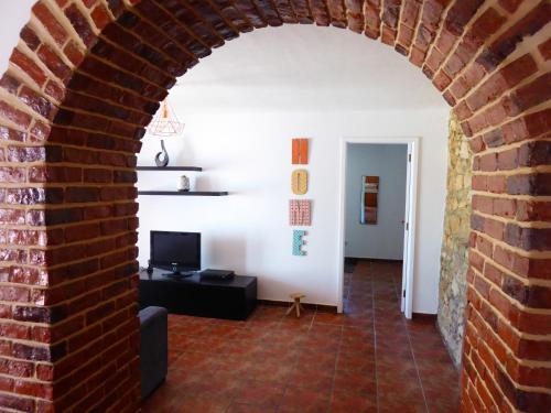 an archway in a living room with a brick wall at Monte da Cascalheirinha in Santo André