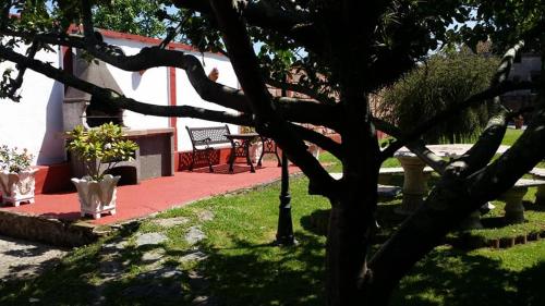 a tree in a park with a table and benches at El Perlindango in Villademar