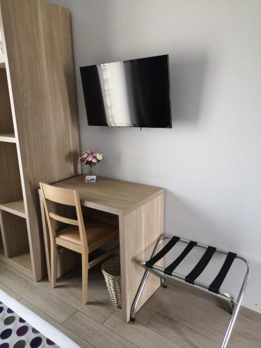 a desk with a chair and a tv on a wall at Atoll Hotel restaurant in Fréjus