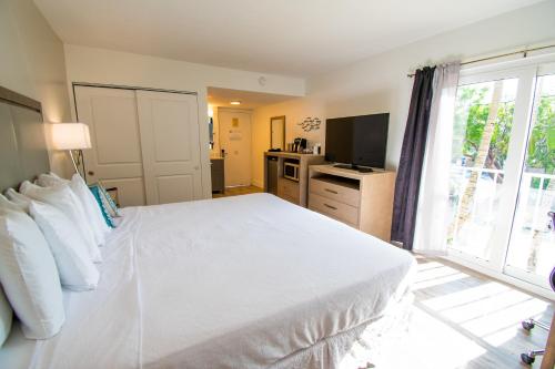 a bedroom with a white bed and a large window at Bayside Inn Key Largo in Key Largo