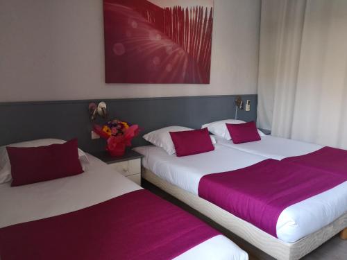 two beds sitting next to each other in a bedroom at Atoll Hotel restaurant in Fréjus