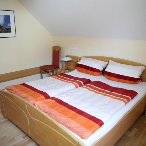 una camera da letto con un grande letto con cuscini a righe di Haus Agnes FeWo 2 a Malborn