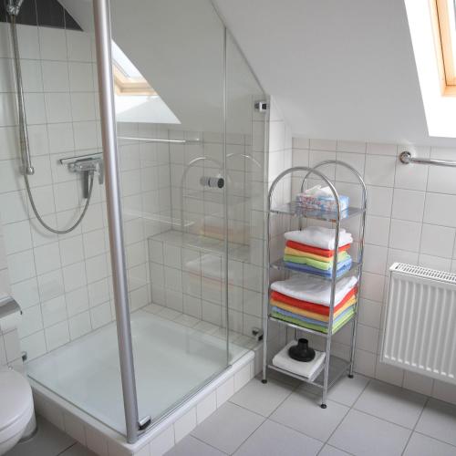 a bathroom with a shower and a stack of towels at Haus Agnes FeWo 2 in Malborn
