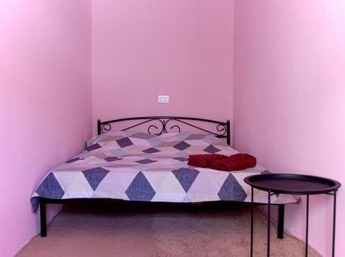 1 Schlafzimmer mit einem Bett mit lila Wänden und 2 Tischen in der Unterkunft квартира в центре in Odessa
