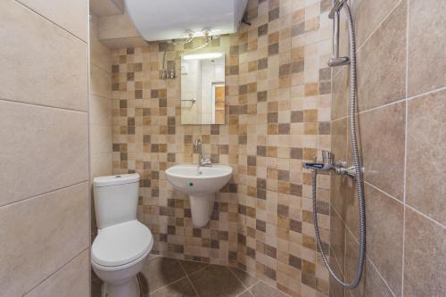 a bathroom with a toilet and a sink and a shower at Kosev Apartment in Veliko Tŭrnovo