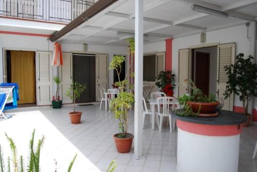 a patio with plants and tables and chairs at Baia Unci in Canneto