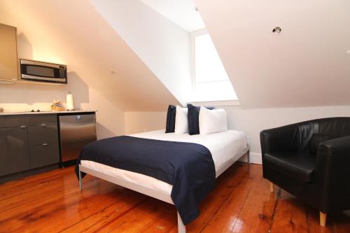 1 dormitorio con 1 cama y 1 silla negra en Charming & Stylish Studio on Beacon Hill #15, en Boston