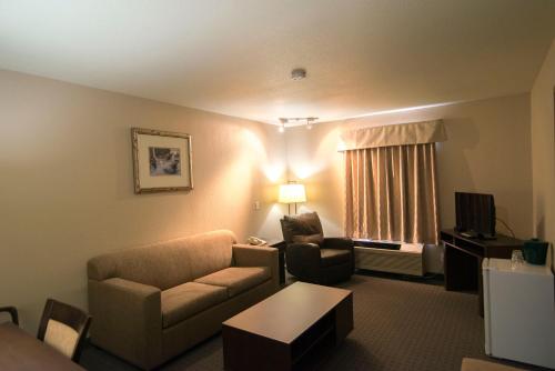 a living room with a couch and a chair at Super 8 by Wyndham Dauphin in Dauphin