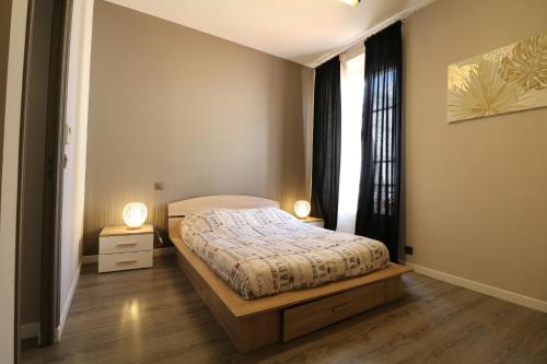 een slaapkamer met een bed en een raam met 2 lampen bij Quality 2 bedroom 9 mins from the Palais 342 in Cannes