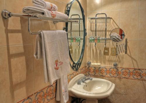 a bathroom with a sink, mirror, and towel rack at Hotel Boutique Parador San Miguel Oaxaca in Oaxaca City