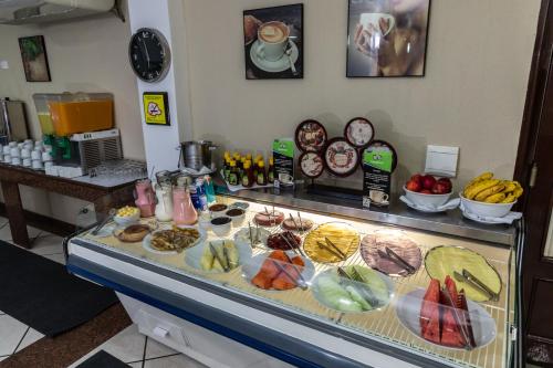 a counter with many different types of food on it at Aguas do Iguaçu Hotel Centro in Foz do Iguaçu