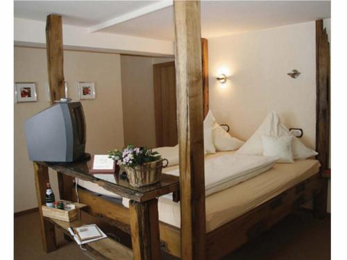 a bedroom with a wooden bunk bed with a television at Hotel Zur Post in Roßbach
