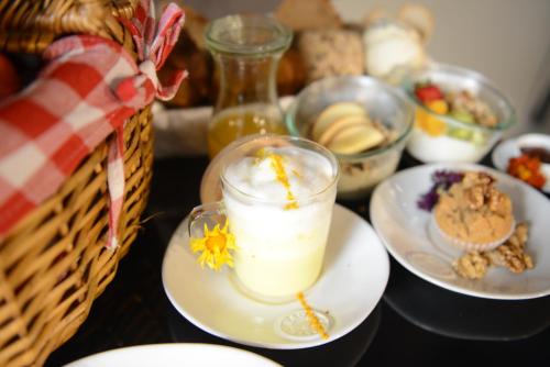 a table with plates of food and a glass of milk at Raw Culture Art & Lofts Bairro Alto in Lisbon