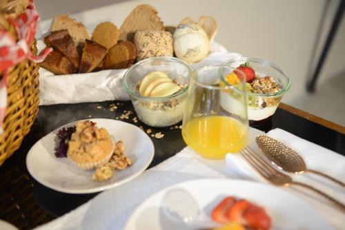 a table topped with plates of food and glasses of orange juice at Raw Culture Art & Lofts Bairro Alto in Lisbon