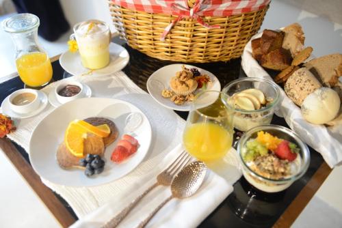 a table with plates of food and a basket of orange juice at Raw Culture Art & Lofts Bairro Alto in Lisbon