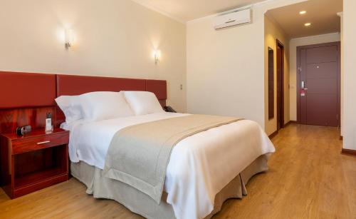 a bedroom with a large bed and a wooden floor at Best Western Estacion Central in Santiago