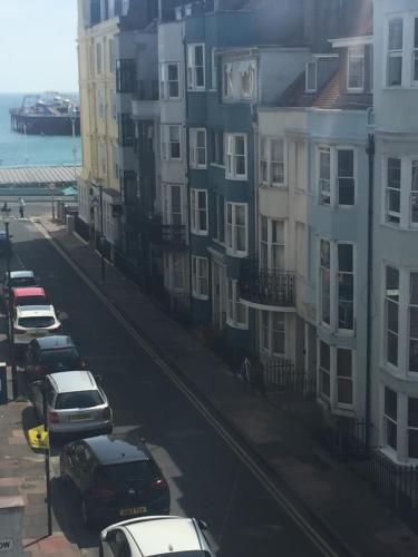 a city street with cars parked in front of buildings at Beachside House in Brighton & Hove