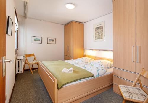 1 dormitorio pequeño con 1 cama y 1 silla en Sylt - Haus Christianenhöhe - App 33, en Westerland