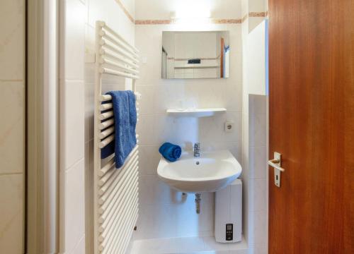 Baño blanco con lavabo y espejo en Sylt - Haus Christianenhöhe - App 33, en Westerland