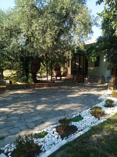 a house with a yard with rocks and trees at Chrisella Villa in Skala Rachoniou