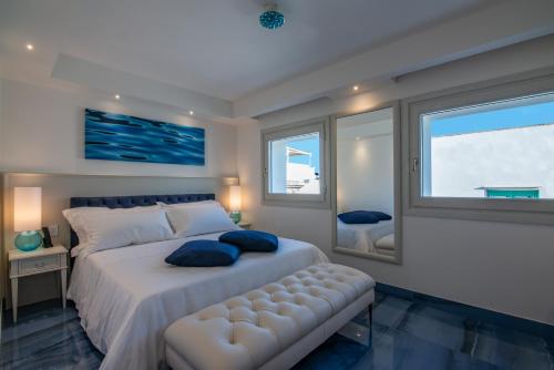a bedroom with a large white bed with blue pillows at Hotel Grotta Palazzese in Polignano a Mare