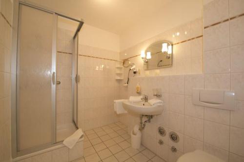 a bathroom with a shower and a sink and a toilet at AKZENT Waldhotel Spa Rügen in Göhren