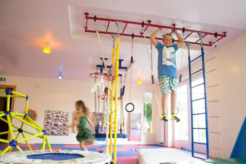 a young boy jumping on a climbing frame in a play room at Reisslerhof in Gröbming