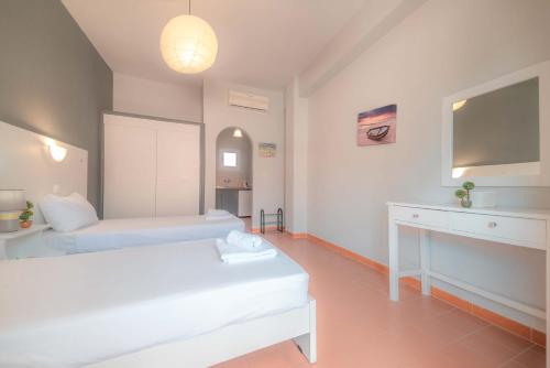 a white room with two beds and a sink at Nine Muses Apartments in Kavos