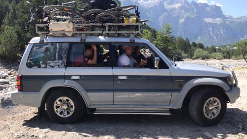 a group of people sitting in the back of a suv at Guesthouse Marashi in Theth
