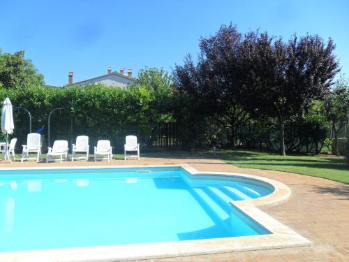 a large swimming pool with chairs and a house at Casale Santa Caterina in Amelia