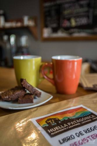 two coffee cups and a plate of food on a table at Hostal Esquina Patagónica in Coihaique