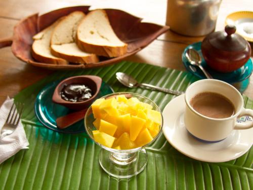 萊蒂西亞的住宿－La Ceiba, Amazonas，绿色托盘,包括一杯咖啡和一盘面包