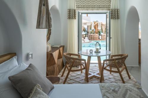 sypialnia z łóżkiem i stołem z krzesłami w obiekcie Virtu Suites w miejscowości Agios Prokopios