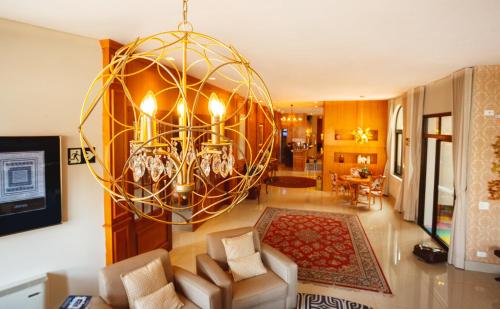 a living room with a large chandelier at Pousada Luis XV in Campos do Jordão