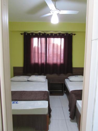 two beds in a room with a window at Hotel Biz a 8 minutos do Brás, a 15 minutos da 25 de março e a 8 minutos do Bom retiro in Sao Paulo