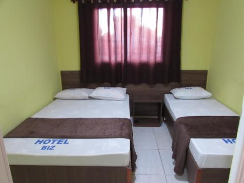 a room with two beds and a window at Hotel Biz a 8 minutos do Brás, a 15 minutos da 25 de março e a 8 minutos do Bom retiro in Sao Paulo