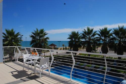 a balcony with a table and chairs next to a swimming pool at Kiara Residence in Giulianova
