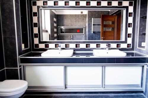 a bathroom with two sinks and a mirror at Apartament Jeziorna in Mrągowo