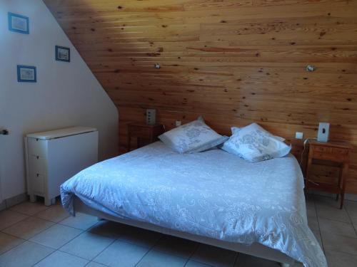 - une chambre avec un lit et un mur en bois dans l'établissement Le nid d'hirondelles - Chambres d'hôtes, à Plougoumelen