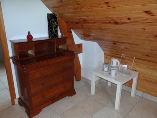 Cette chambre comprend une commode et une petite table. dans l'établissement Le nid d'hirondelles - Chambres d'hôtes, à Plougoumelen